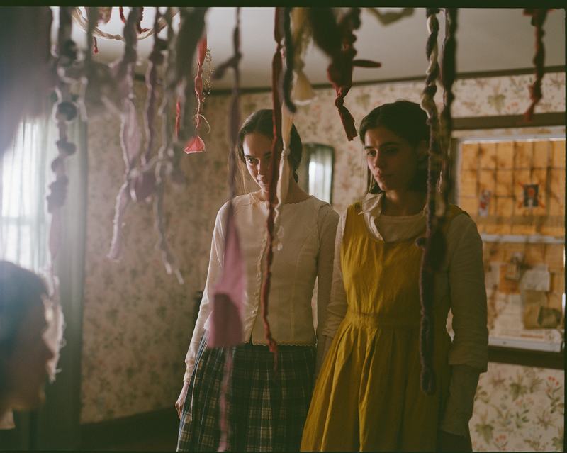 The sisters stand among hanging ribbons in the convent.